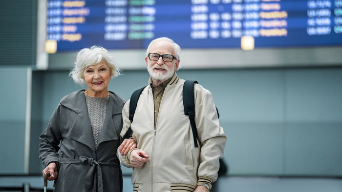 Retired couple at an airport as more people consider moving abroad for retirement in 2026.