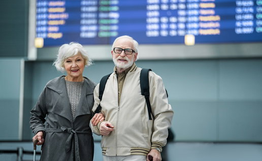 Retired couple at an airport as more people consider moving abroad for retirement in 2026.