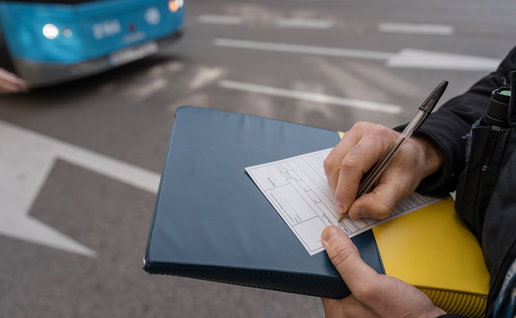 Traffic officer issuing a roadside penalty notice during a vehicle inspection in Spain.