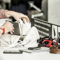 Passengers remove electronic devices and personal items from hand luggage during an airport security screening process.