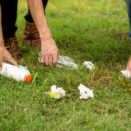 Young people collecting rubbish off the floor