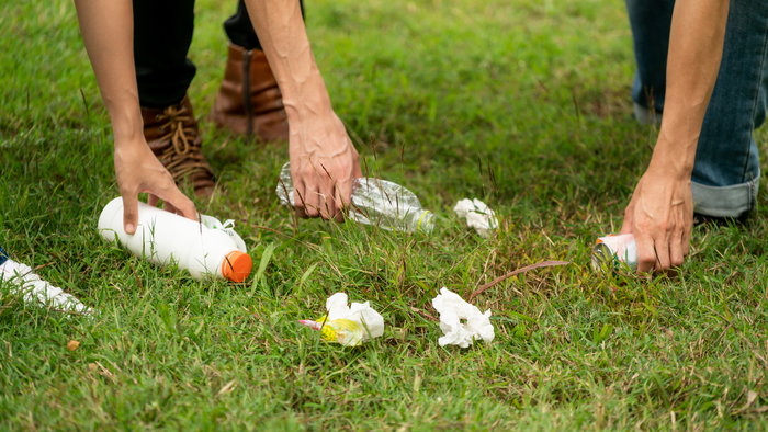 Young people collecting rubbish off the floor
