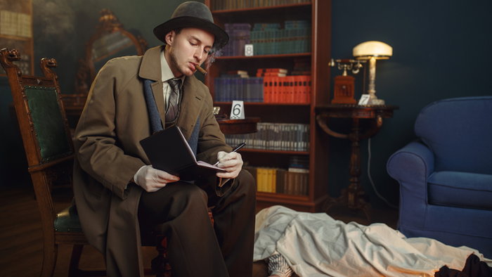 Male detective with cigar writes in notebook