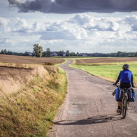 Man cycling on a country road in Poland