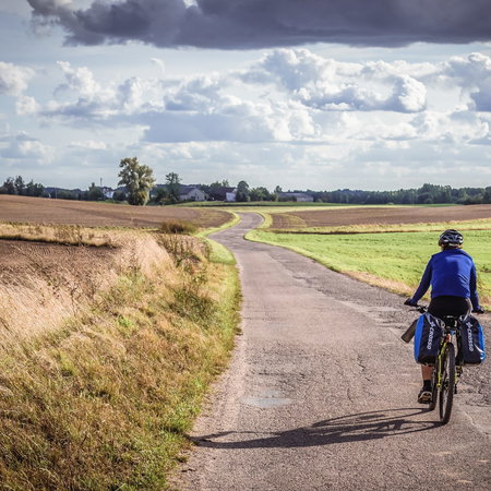 Man cycling on a country road in Poland