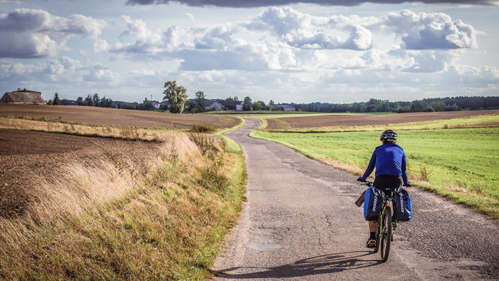 Man cycling on a country road in Poland