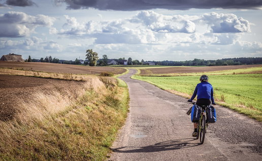 Man cycling on a country road in Poland