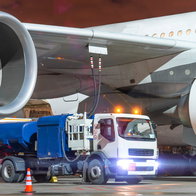 A truck under the wing of a plane refuelling it