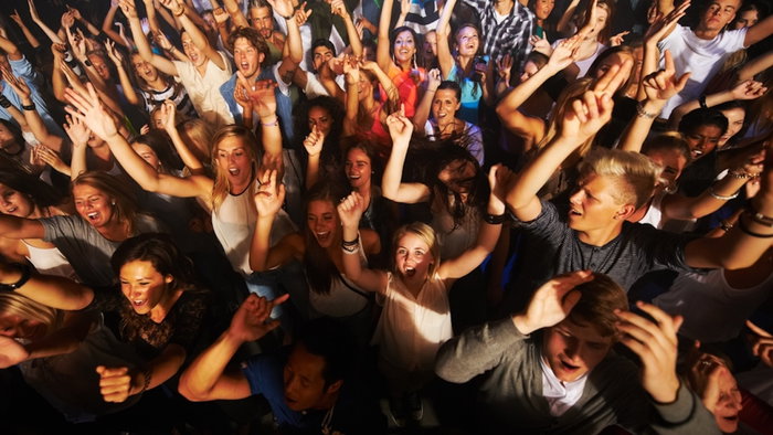 Music, dance and party with crowd at concert for rock, live band performance or festival. New year, energy and disco with audience of fans listening at celebration for techno, rave or nightclub event