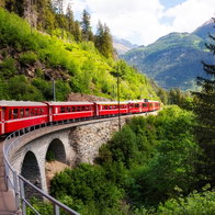 Red train moving in beautiful mountain landscape.