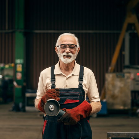 Old man working in metal workshop