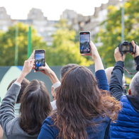 Crowd of people raising smartphones and cameras to capture an event/incident