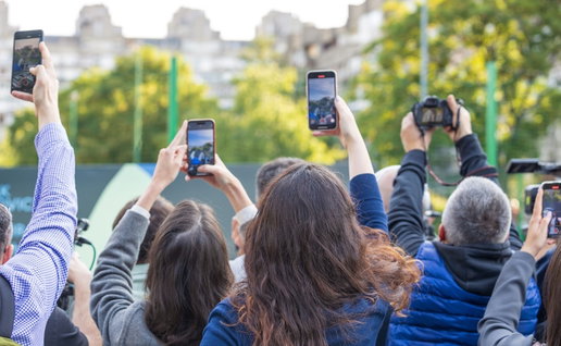 Crowd of people raising smartphones and cameras to capture an event/incident