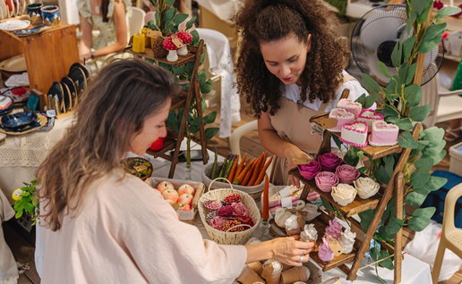 Woman Demonstrates and Sells UniqueCandles to Buyer at Craft Fair