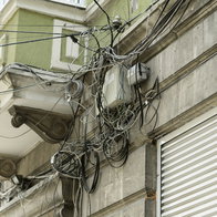 Mix of cables on the wall of a building