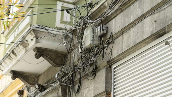 Mix of cables on the wall of a building