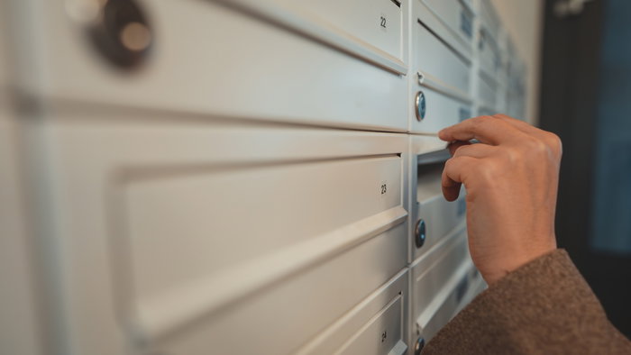 woman opening post pox to collect letter