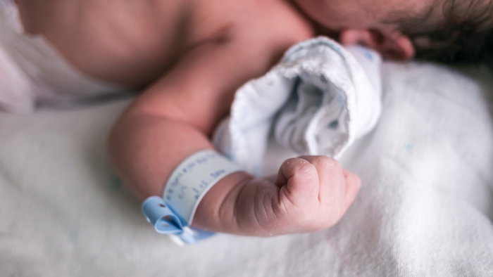 Arm of a new born babies with an ID tag around his wrist