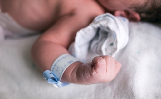 Arm of a new born babies with an ID tag around his wrist