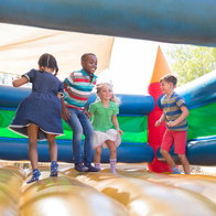 Children playing on bouncy castle at playground
