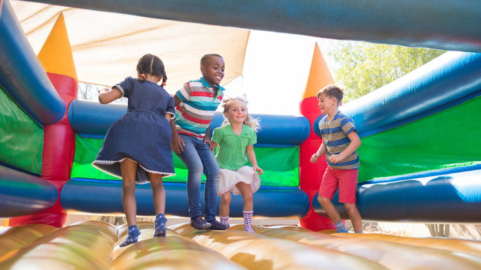 Children playing on bouncy castle at playground