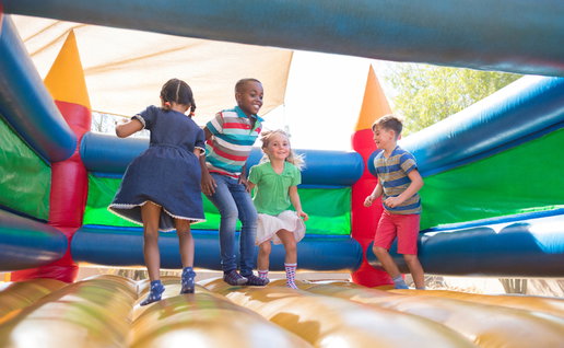 Children playing on bouncy castle at playground