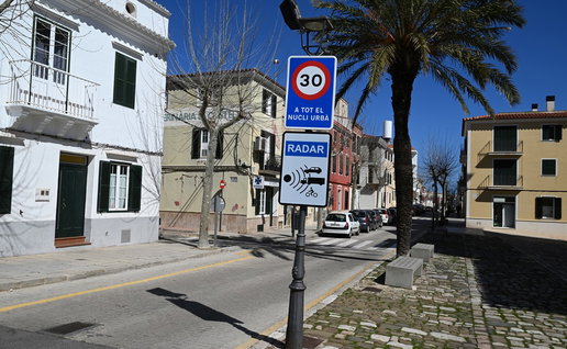Radar speed camera warning sign on a residential street in Spain with a 30 km/h speed limit displayed.