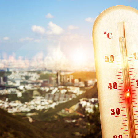 Thermometer showing extreme heat above 40C overlooking a Spanish city during unusually high summer temperatures.