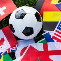 a football on world flags in grass representing the World Cup