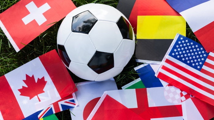a football on world flags in grass representing the World Cup