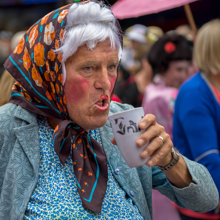 Man in fancy dress holding a drink on Benidorm Strip.