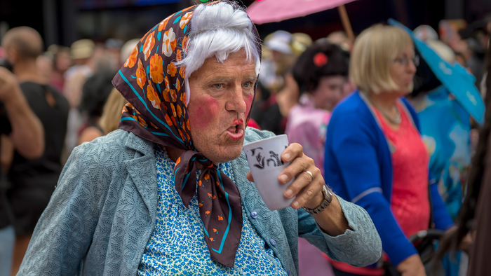 Man in fancy dress holding a drink on Benidorm Strip.