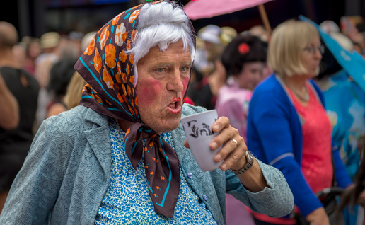 Man in fancy dress holding a drink on Benidorm Strip.