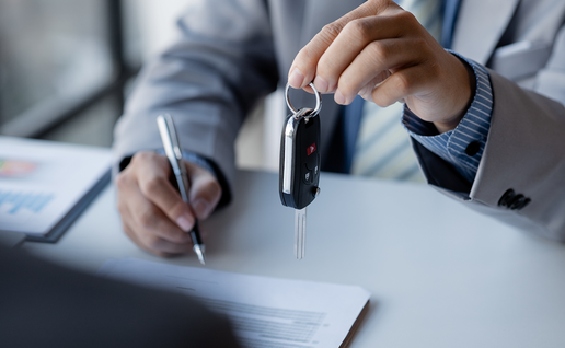 Person handing over keys at the reception of a car hire office.