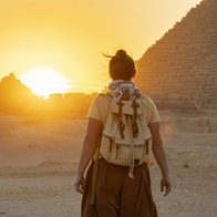 Person walking towards the sunset near the Pyramids of Egypt