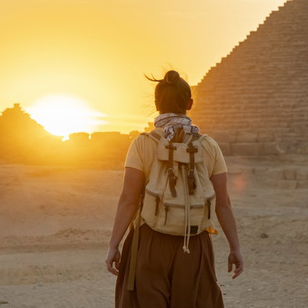 Person walking towards the sunset near the Pyramids of Egypt