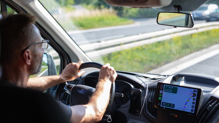 Driver behind the wheel on a European motorway during a daytime journey.
