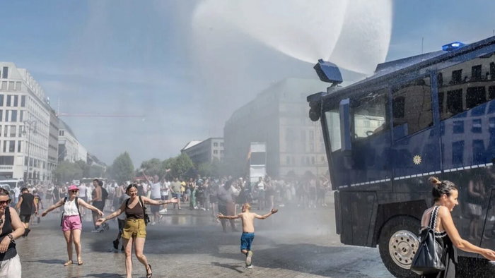 Crowd control: Berlin police deploy water cannon to cool people down.