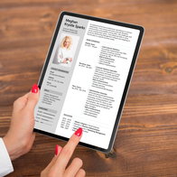 Woman using a tablet to look at a copy of a CV