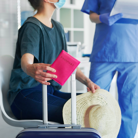A woman in a hospital waiting room with her passport talking to a doctor