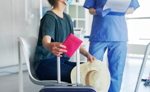 A woman in a hospital waiting room with her passport talking to a doctor
