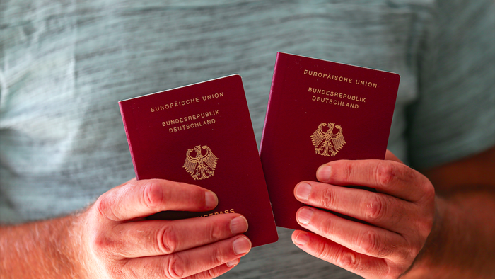 A man holding two German passports