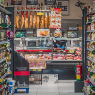 An aisle in a supermarket with the butchers at the end