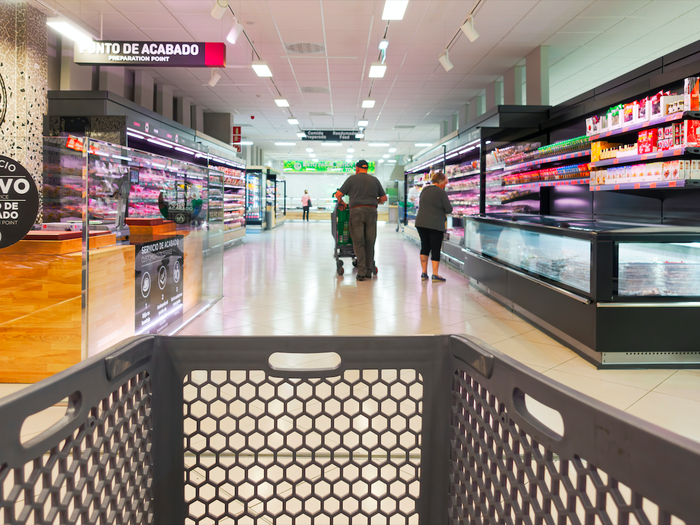 View of the supermarket aisle with a shopping trolley in the foreground