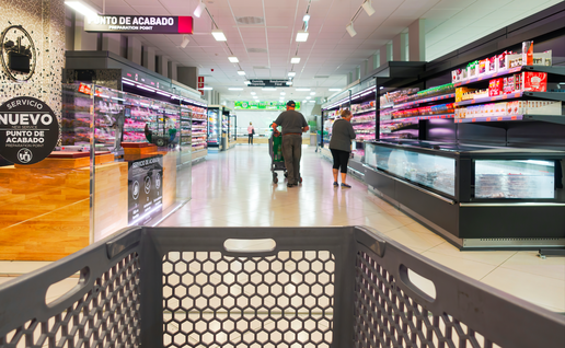 View of the supermarket aisle with a shopping trolley in the foreground