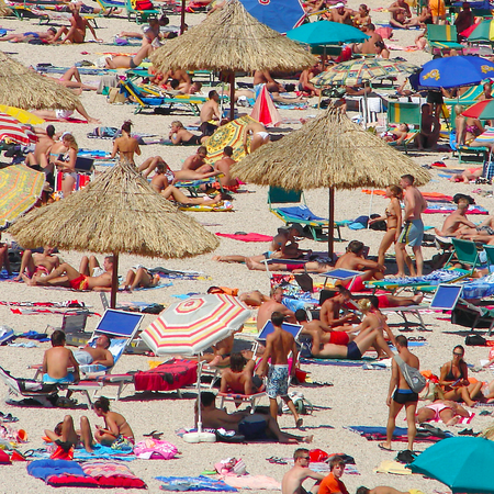 A packed beach with tourists