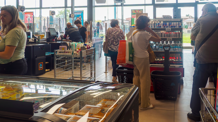 Customers utilizing self checkout kiosks at a contemporary ALDI store