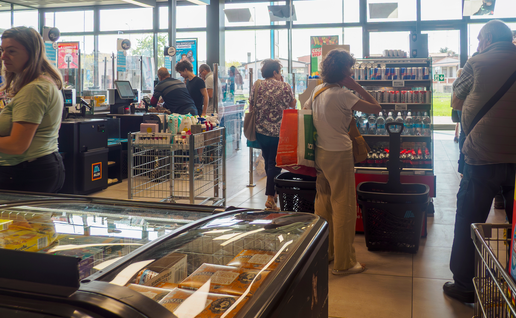 Customers utilizing self checkout kiosks at a contemporary ALDI store