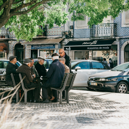 Elderly Portuguese locals sit on the bench