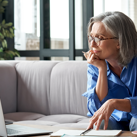 Retired person in Spain reviewing pension paperwork before returning to part-time work.